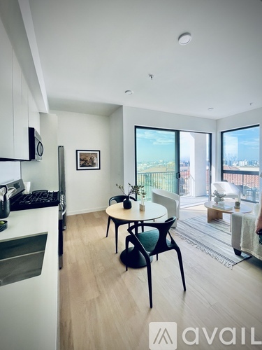 A kitchen with a table and chairs and a window overlooking a cityscape.
