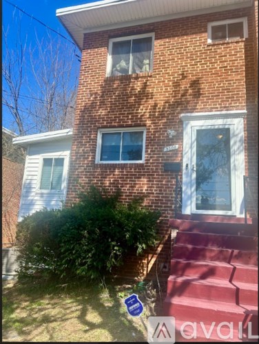 A red brick house with a blue sign in front.