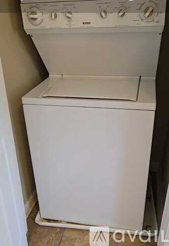 A white washing machine with a top control panel and a door.