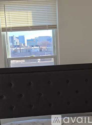 A window with blinds overlooking a city street.