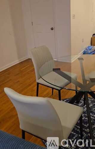 A dining room with a glass table and chairs.