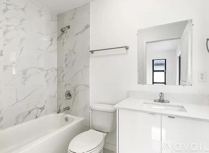 A white bathroom with a marble patterned shower.