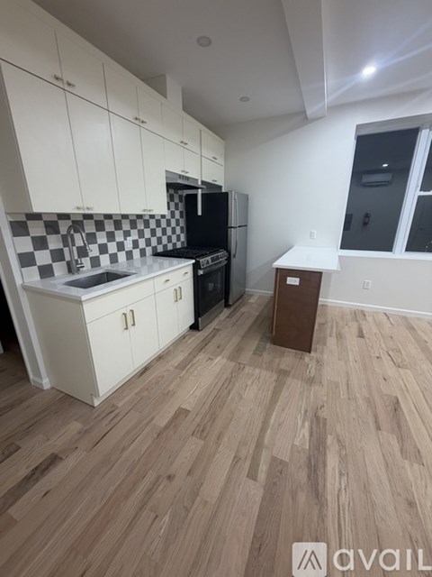 A kitchen with white cabinets and a black and white checkered backsplash.