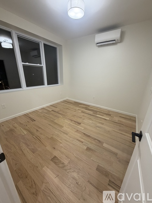 A room with wooden flooring and a window.
