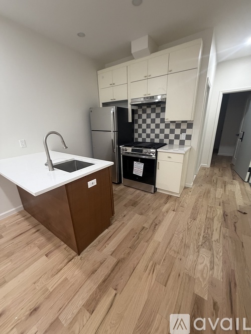 A kitchen with a white countertop and wooden flooring.