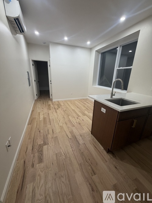 A kitchen area with wooden flooring and a sink.