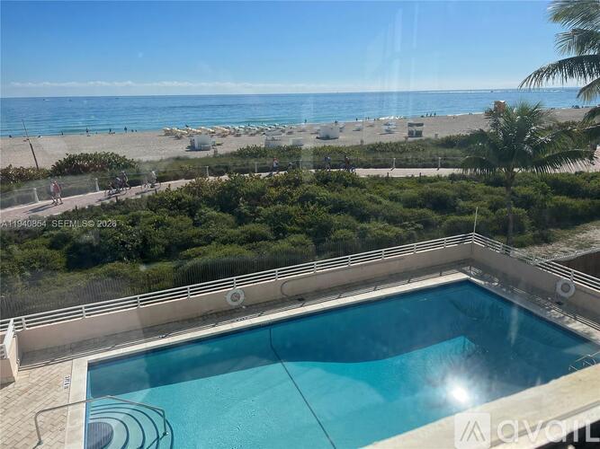 A swimming pool with a view of the beach and the sea.