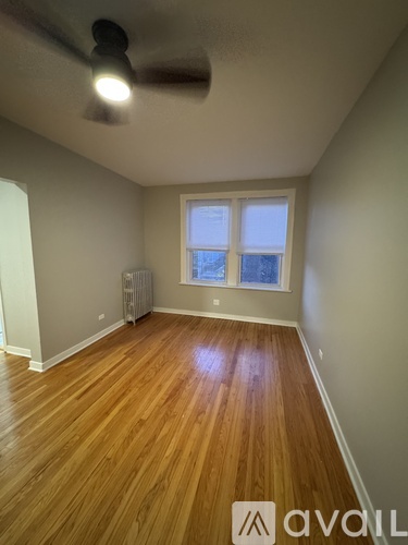 A room with wooden floors and a ceiling fan.