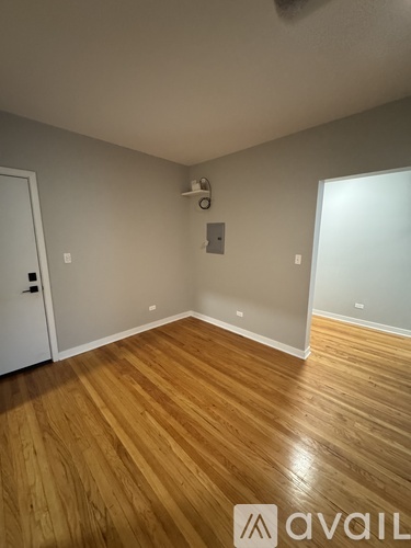 A room with wooden flooring and a white door.