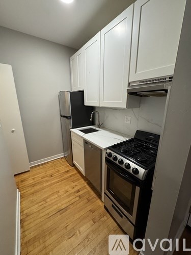 A kitchen with white cabinets and a black stove top.