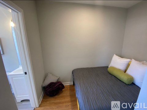 A bedroom with a bed, pillows, and a blanket.
