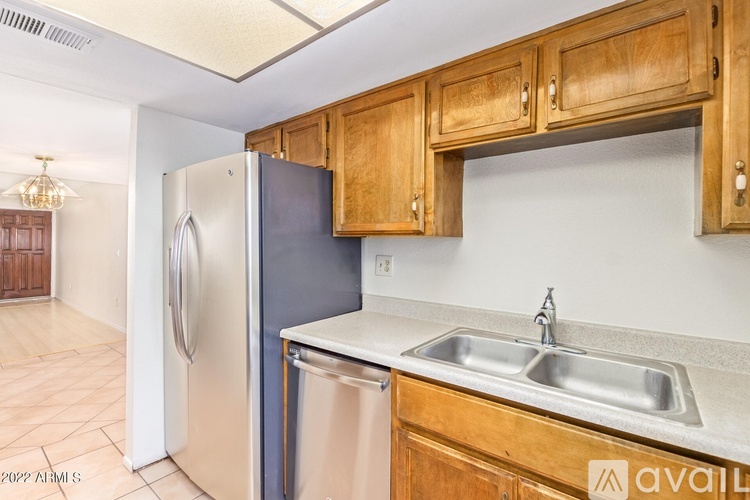 A kitchen with wooden cabinets and a stainless steel refrigerator.