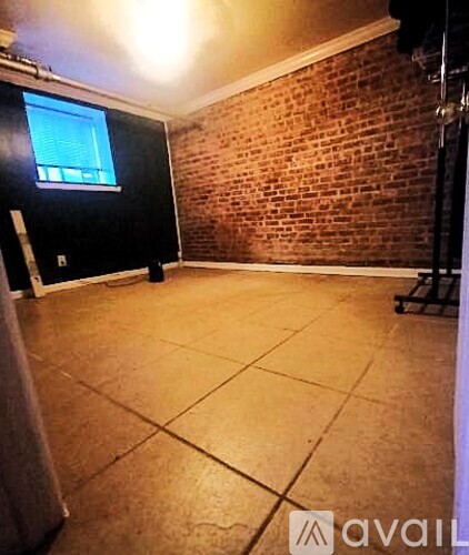 A room with a brick wall and a flat screen TV mounted on the wall.
