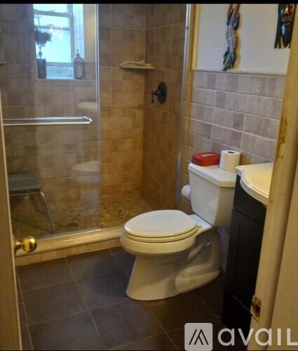 A white toilet in a bathroom with a glass shower door.