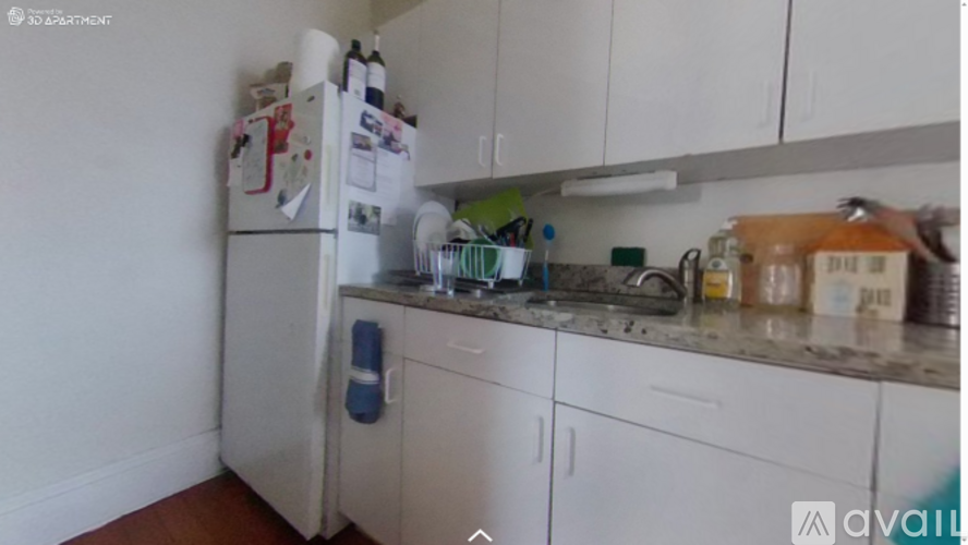 A kitchen with white cabinets and a refrigerator with magnets on it.