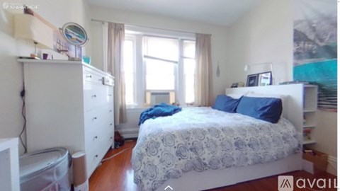 A bedroom with a bed, dresser, and window.