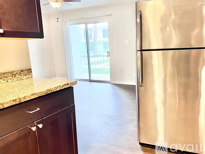 A kitchen with a stainless steel refrigerator and wooden cabinets.