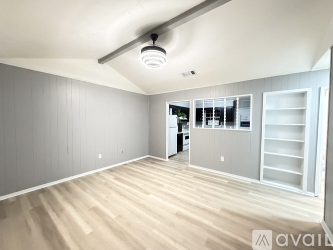 A room with wooden floors and grey walls.