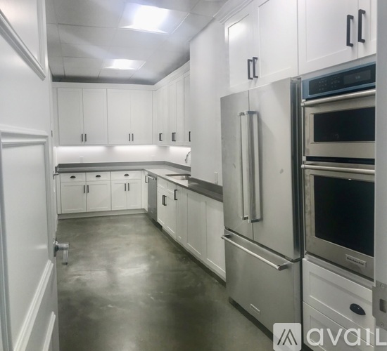 A kitchen with white cabinets and stainless steel appliances.