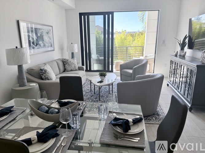 A modern dining room with a glass table set for two.