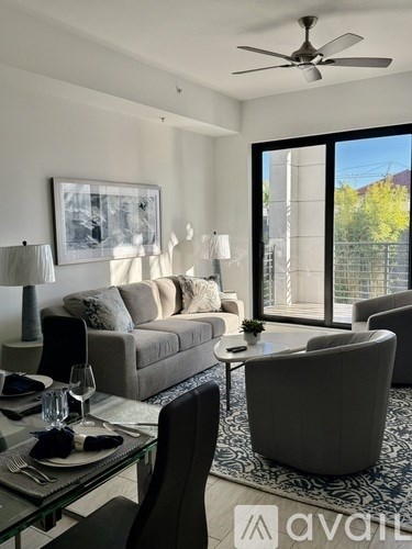 A modern living room with a glass table set for two.
