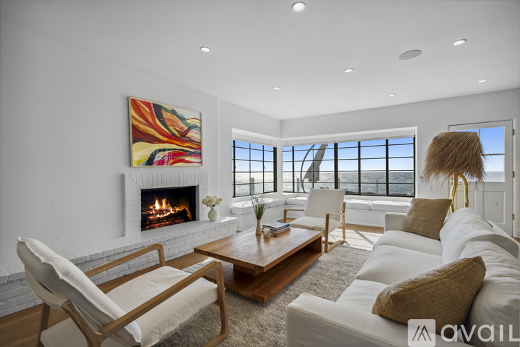 A living room with a fireplace and a painting on the wall.
