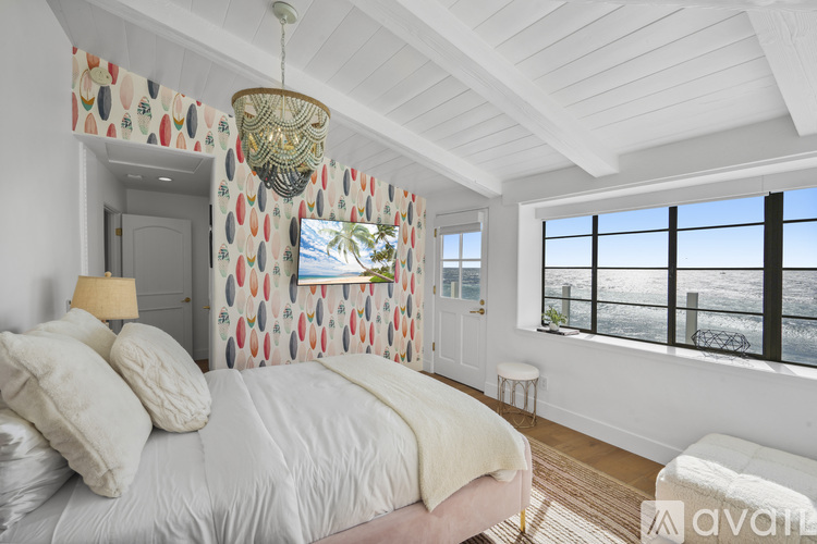 A bedroom with a large bed and a chandelier.