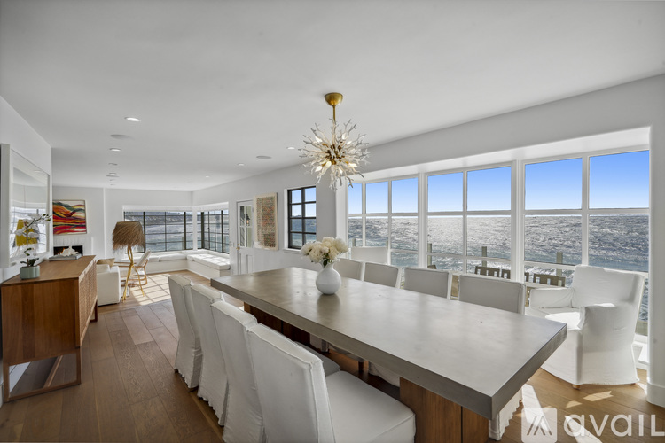 A modern dining room with a long table and chairs.