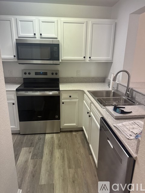 A kitchen with white cabinets and a stainless steel dishwasher.