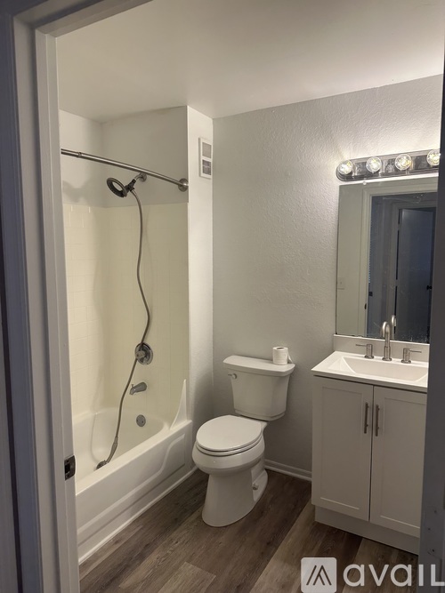 A bathroom with a toilet, sink, and shower.