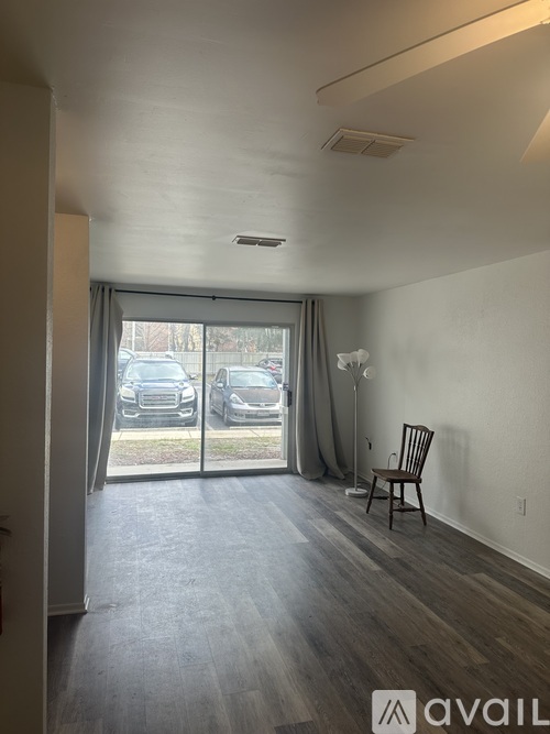 A room with a wooden floor and a chair is shown.