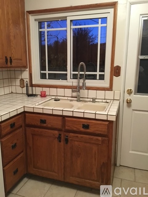 A kitchen with wooden cabinets and a window above the sink.