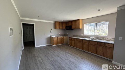 A spacious kitchen with wooden cabinets and a window.