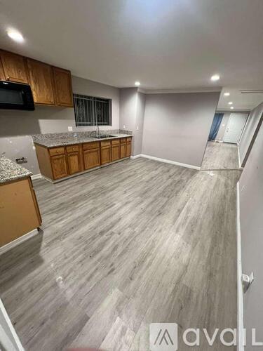 A spacious room with wooden cabinets and a grey countertop.