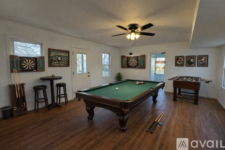 A room with a pool table and a dartboard.