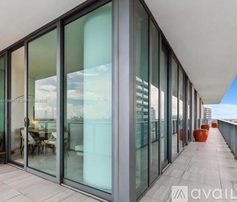A balcony with glass doors and a table and chairs inside.