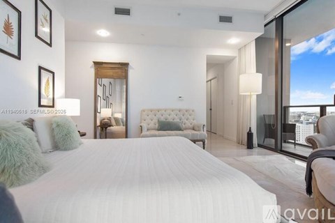 A bedroom with a large bed and a view of the city.