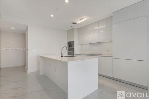 A modern kitchen with white cabinets and a central island.