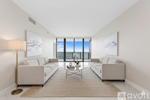 A living room with two couches, a coffee table, and a large window.