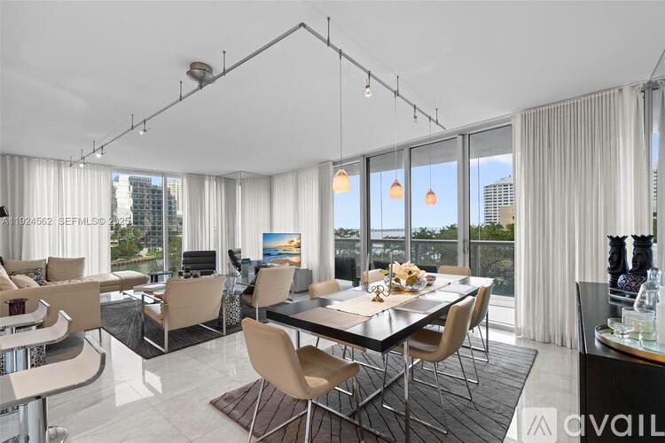A modern dining room with a glass table and chairs.