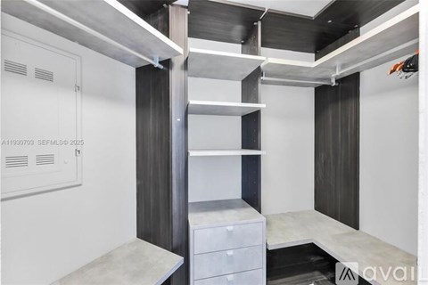 A modern kitchen with white cabinets and a stainless steel range hood.