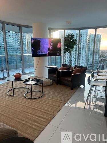 A living room with a television and a view of the city.