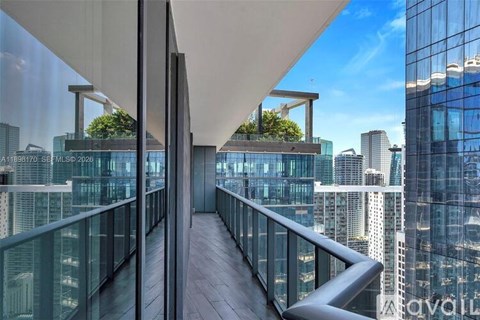 A modern balcony with glass railings overlooks a cityscape.