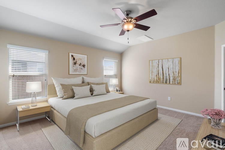 A bedroom with a large bed and a ceiling fan.