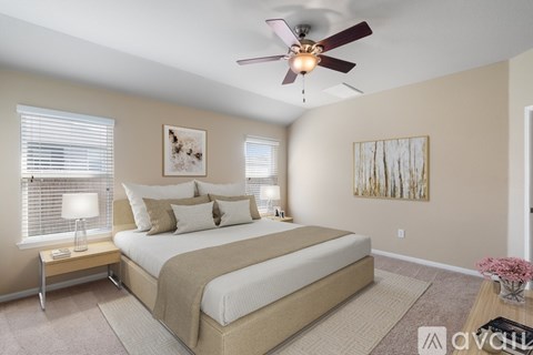 A bedroom with a large bed and a ceiling fan.