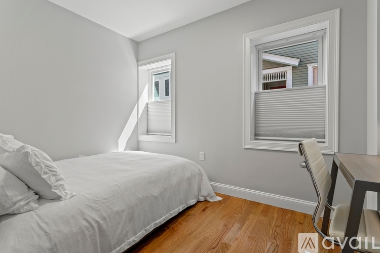 A bedroom with a bed, chair, and window.