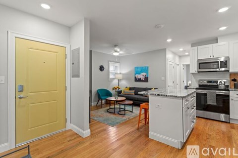 A kitchen with a yellow door and a dining table with chairs.
