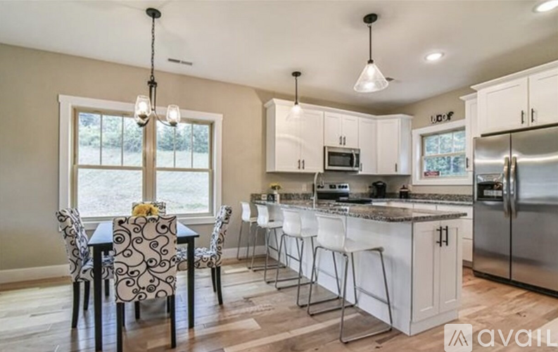 A kitchen with a table and chairs in front of a window.