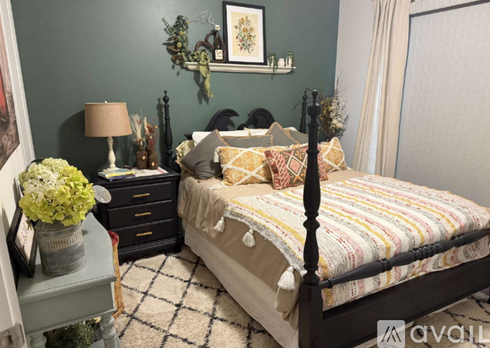 A bedroom with a bed, nightstand, and lamp.