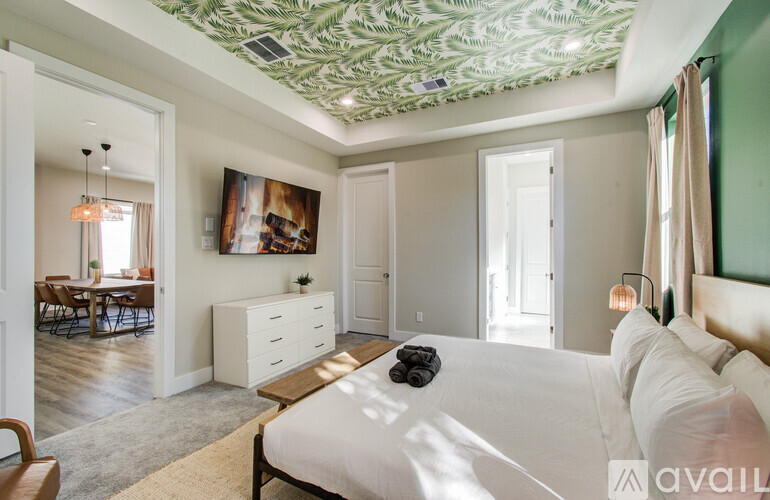 A bedroom with a large bed and a painting on the wall.